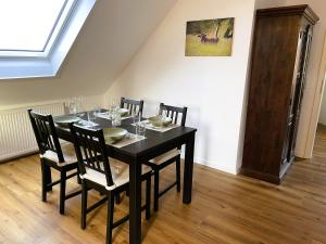 a dining room with a black table and chairs at Harzhaus Drei Hexen in Tanne