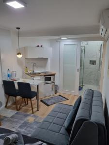 un soggiorno con divano blu e una cucina di Apartments Deni a Mostar