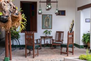 una habitación con sillas y una mesa con una foto en la pared en Hotel Casa Antigua Buga, en Buga