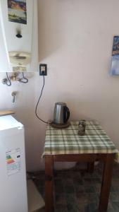 una cocina con mesa y hervidor de agua. en Residencia zona sierras chicas (casa) El talar en Mendiolaza