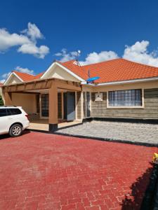 une maison avec un toit rouge dans une allée en briques dans l'établissement Savanna Greens Joska, à Nguluni