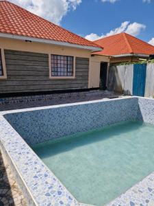 a swimming pool in front of a house at Savanna Greens Joska in Nguluni