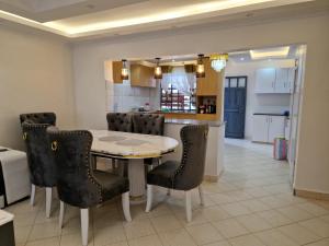 - une cuisine et une salle à manger avec une table et des chaises dans l'établissement Savanna Greens Joska, à Nguluni