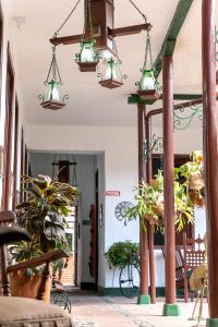 a hallway with potted plants and lights at Hotel Casa Antigua Buga in Buga