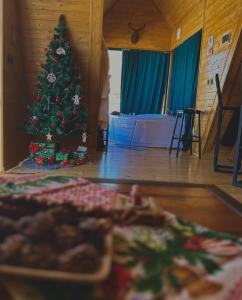 a christmas tree in a room with a pile of presents at Vista cottage in Kazbegi