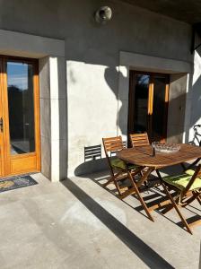 een houten tafel en stoelen op een terras bij Superbe appartement dans un mas in Nîmes