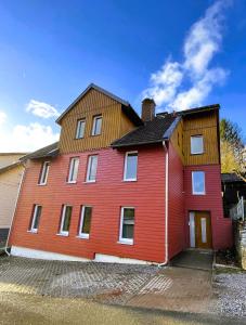 a large red house with a wooden roof at Harzhaus Drei Hexen in Tanne