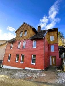 una gran casa roja con techo de madera en Harzhaus Drei Hexen, en Tanne