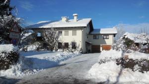 ein weißes Haus mit Schnee auf dem Boden in der Unterkunft Haus Aigner in Piding