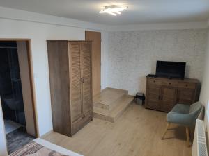 sala de estar con armario de madera y TV en Ubytování u Parku, en Lednice