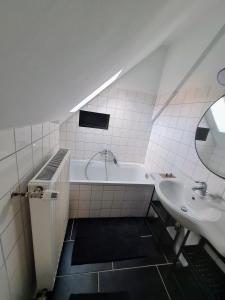 a bathroom with a white tub and a sink at The Cottage in Reichenau