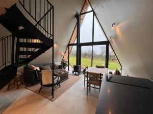 uma sala de estar com uma escada em espiral e uma mesa em Wilder Retreats - A Frame Cabins em Haverfordwest