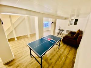 a living room with a ping pong table and a couch at Maison de ville haut de gamme En face du stade de France in Saint-Denis