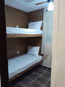 a room with two bunk beds in a room at Aconchego da Gil in Rio das Ostras