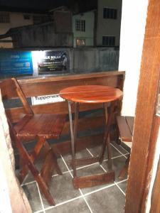 a wooden table and a chair next to a counter at Aconchego da Gil in Rio das Ostras