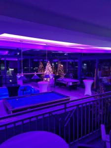 uma discoteca com árvores de Natal e mesas de pingue-pongue em Tc Lux em Nemenikuće