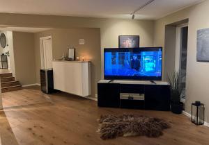 a living room with a large flat screen tv at Unik plass ved Nidelva in Trondheim