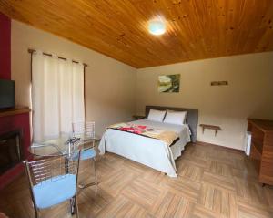 um quarto com uma cama e um tecto de madeira em Pousada Rural Recanto do Lago em Pedra Azul