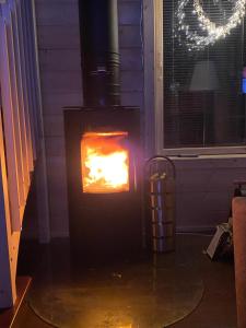 a wood stove with a fire in a room at Villa Sappee in Sappee +3 photos