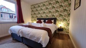 a bedroom with a bed with white sheets and red pillows at ARCHIPEL - Balkon - nahe Hamburg - Lounge - Smart TV - Parking in Geesthacht