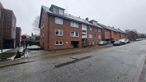 an empty street with a brick building and cars parked at ARCHIPEL - Balkon - nahe Hamburg - Lounge - Smart TV - Parking in Geesthacht
