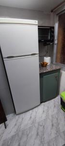 um frigorífico branco numa cozinha com um micro-ondas em Real Fábrica del Conde de Aranda em Alcora