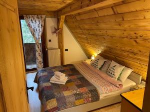 a bedroom with a bed in a wooden cabin at Cabana Craita in Vişeu de Sus