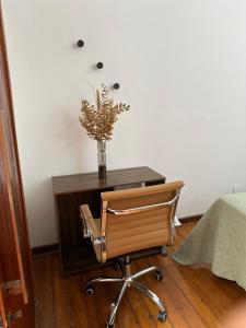 uma secretária com uma cadeira e um vaso de flores em 7 persons - 140 m2 - Sambódromo - LAPA - House - Casa - Netflix no Rio de Janeiro