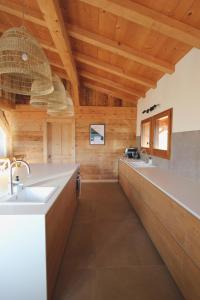 cocina con 2 lavabos y techos de madera en Charmant demi-chalet à la montagne, en Notre-Dame-de-Bellecombe
