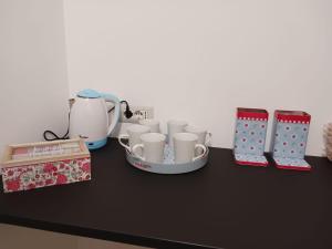 un tavolo con tazze, un set per la preparazione del tè e una scatola di MOM'S HOUSE VOMERO a Napoli