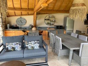 sala de estar con sofá azul y mesa en agréable chambre d hôte avec piscine et jacuzzi, en Thégra