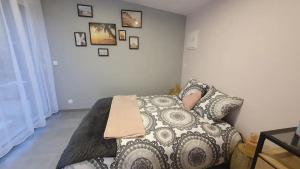 a bedroom with a bed with a pillow and pictures on the wall at Cottage de la mare aux chèvres in Reux