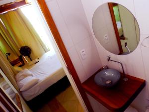 uma pequena casa de banho com um lavatório e um espelho em Atlantic Hospedagem em São Sebastião