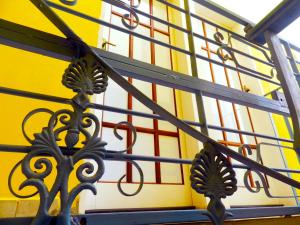サンセバスチャンにあるAtlantic Hospedagemの黄色い壁前の金属製手すり