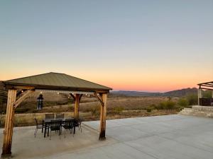 cenador con mesa y sillas en el patio en Casa de campo con vistas espectaculares, en Nogales