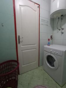 uma lavandaria com uma porta e uma máquina de lavar roupa em New Year's Eve em Sarajevo