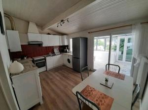 a kitchen with a table and chairs and a kitchen with at Toulousaine avec jardin proche centre wifi in Toulouse