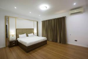 a hotel room with a bed and a window at Unit i2 City House (Sleeps 6) in Lagos