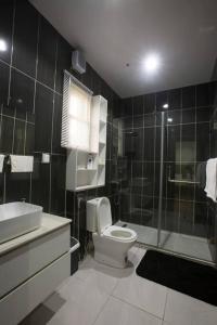 a bathroom with a toilet and a sink and a shower at Unit i2 City House (Sleeps 6) in Lagos