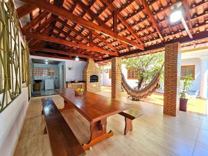 ein Esszimmer mit einem Holztisch und einer Bank in der Unterkunft Linda Edícula com Churrasqueira em casa de Familia in Foz do Iguaçu