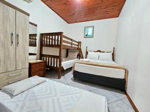 a bedroom with two beds and a bunk bed at Linda Edícula com Churrasqueira em casa de Familia in Foz do Iguaçu