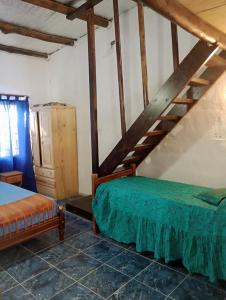 a bedroom with a bed and a wooden staircase at Casa tipo cabaña El Faro (con seña) in Mar del Plata