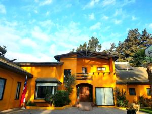 una casa amarilla con una bandera delante de ella en Casa Felice Altovalsol en La Serena