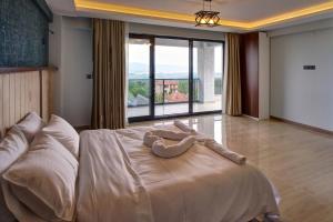 a bedroom with a large bed with a large window at Timeless Kartepe in Kartepe