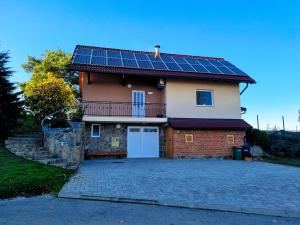 une maison avec des panneaux solaires sur le toit dans l'établissement POČITNIŠKA HIŠA SONČNI VRH, à Spodnji Ivanjci