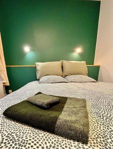 ein Schlafzimmer mit einem großen Bett und einer grünen Wand in der Unterkunft Le Charme des Remparts Boulonnais in Boulogne-sur-Mer