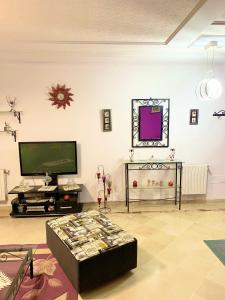 a living room with a tv and a coffee table at Dream Appartement El Aouina in Tunis