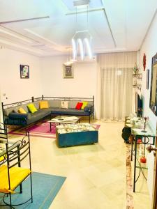 uma sala de estar com um sofá e uma mesa em Dream Appartement El Aouina em Tunes