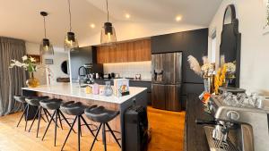 a kitchen with a island with bar stools at Spacious and Luxurious Family Home in Queenstown