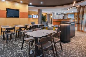 a restaurant with tables and chairs and a flat screen tv at SpringHill Suites by Marriott Lancaster Palmdale in Lancaster